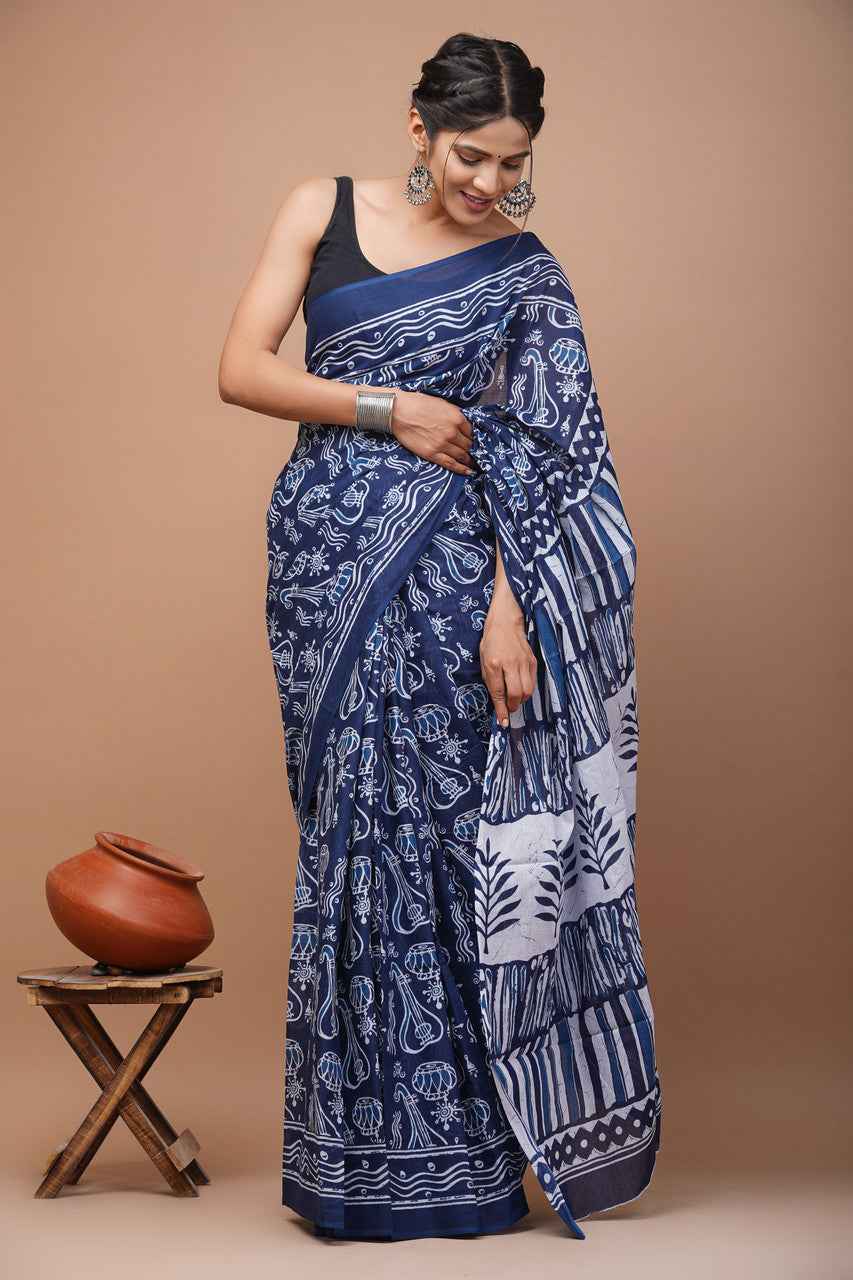 Woman wearing a blue and white patterned saree against a beige background
